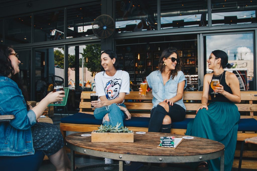 一群女子坐在餐廳椅子上愉快聊天的照片